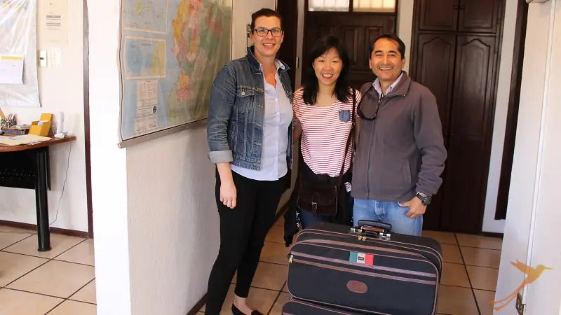 client with suitcase and soleq travel staff
