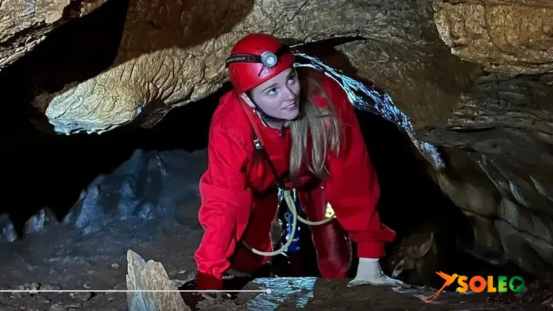 young woman in a cave with safety equipment