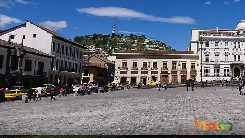 Plaza de San Francisco en el Centro Histórico de Quito – rodeada de arquitectura colonial y calles adoquinadas, con la Virgen de El Panecillo como telón de fondo.