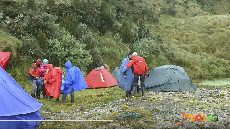 Group of hikers camping on the Condor Trek in Ecuador, surrounded by high Andean landscapes and mist-covered mountains.
