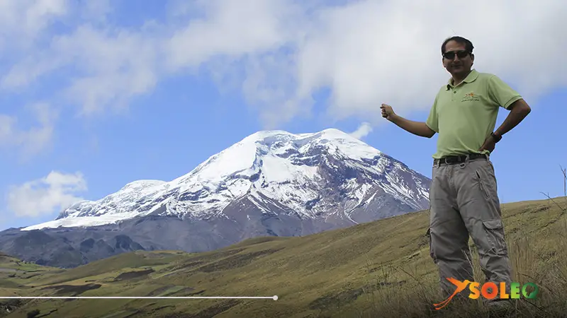 A man enjoying his tour near Chimborazo Volcano, surrounded by the breathtaking Andean landscape under a clear blue sky.