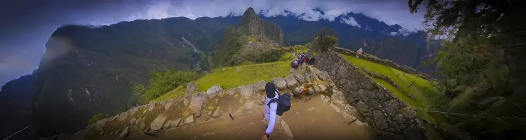 Panorama of Machu Picchu in Peru with a view of Huayna Picchu, Inca ruins, and visitors on the stone terraces