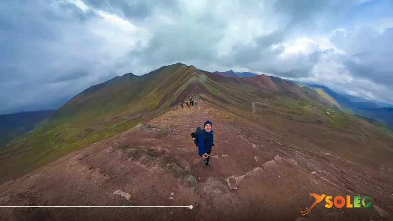 Excursionistas en la cresta de la montaña Arcoíris de Perú (Vinicunca) – Vista sobre las coloridas crestas montañosas de los Andes peruanos.