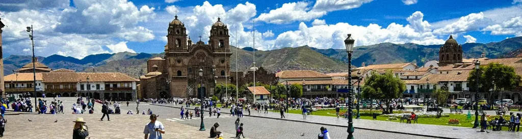 Plaza de Armas in Cusco with the cathedral and the Andes mountains in the background
