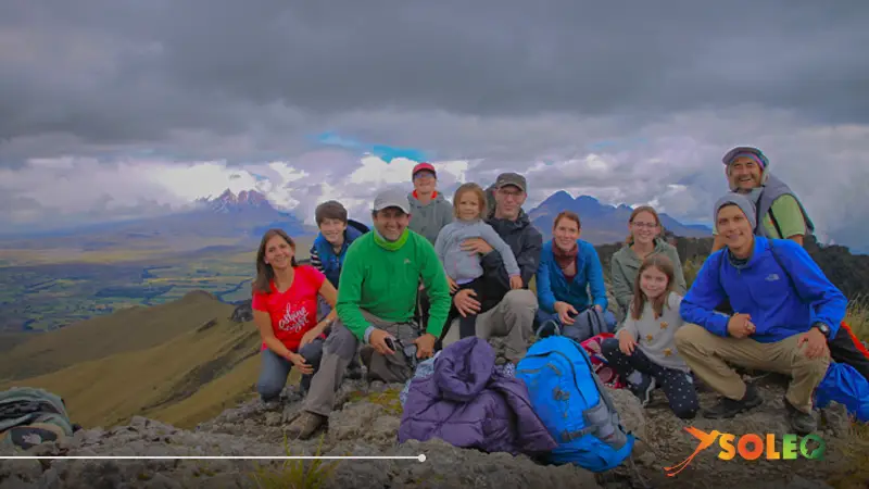 A tour group at the summit of the Pasochoa volcano, looking out over the Andean landscape along the Avenue of the Volcanoes in Ecuador