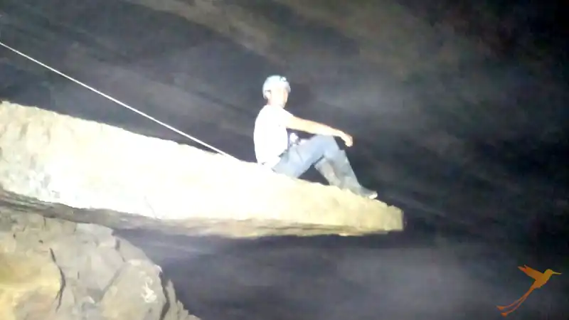 Omar sitting on flat rock inside Tayos cave